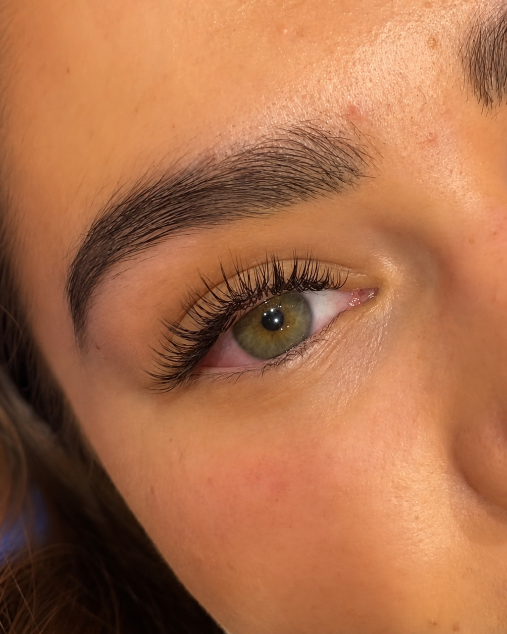 Green-eyed client wearing a soft classic lash set by Mimmo Beauty.
