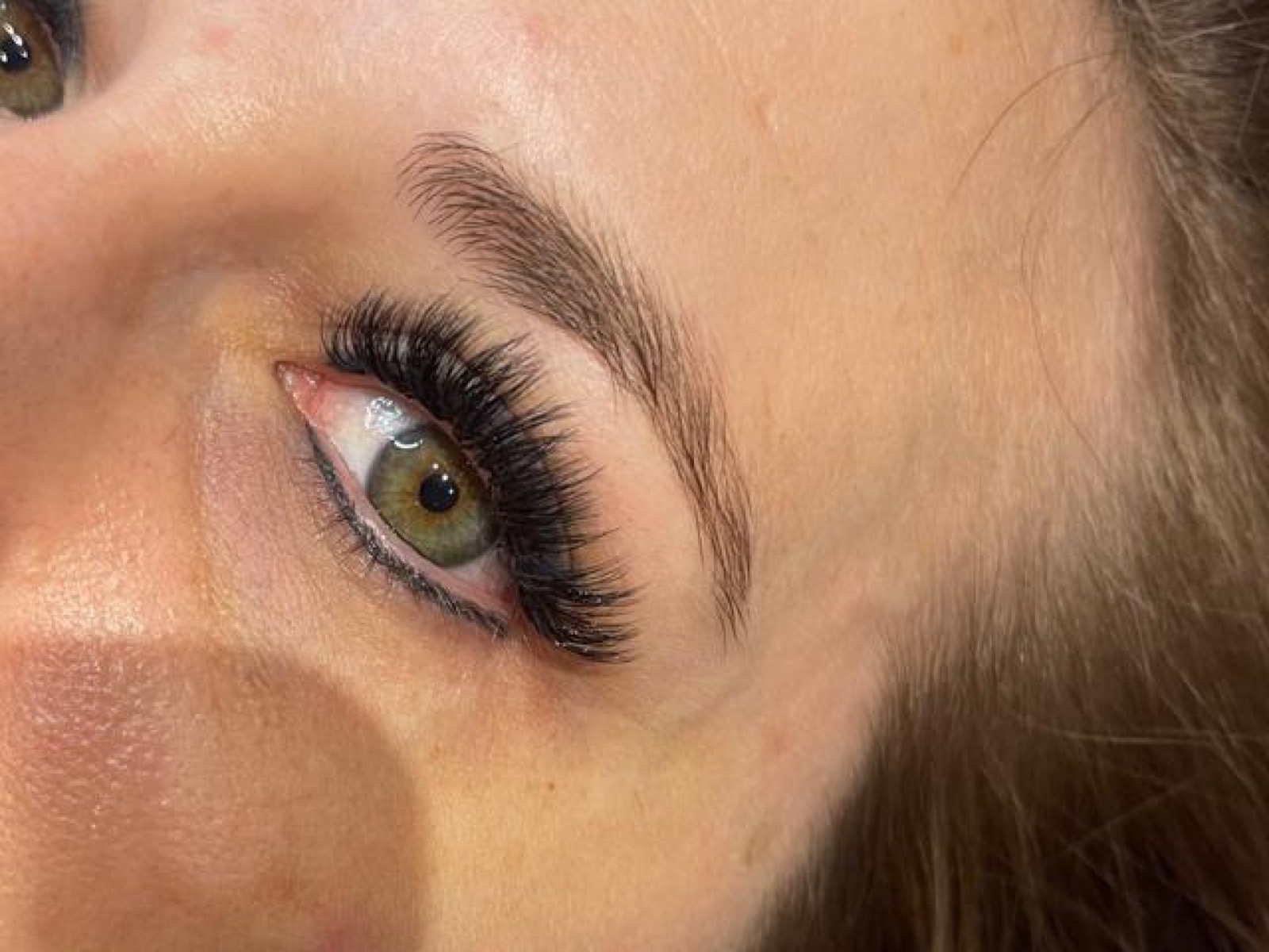 Close-up of a green eye framed by a full volume lash set from Mimmo Beauty.